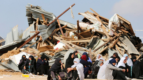 Mujeres sentadas ante sus hogares demolidos en el pueblo beduino de Umm al-Hiran, en el desierto israelí de Negev. / REUTERS