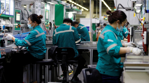 Trabajadores en la línea de producción de una planta de componentes electrónicos de Pekín. REUTERS/Florence Lo