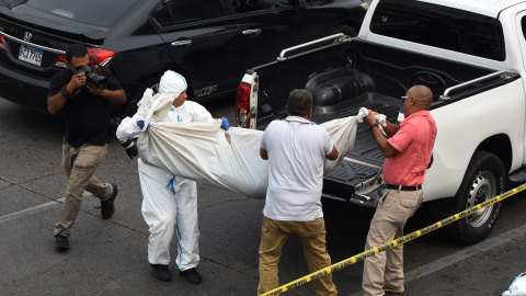 El personal de medicina forense traslada el cuerpo de uno de los jóvenes asesinados a tiros por pandilleros en las inmediaciones de un centro comercial en Tegucigalpa el 26 de abril de 2023.