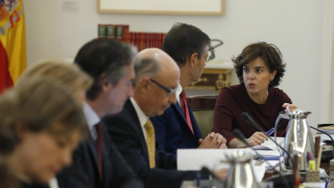 La vicepresidenta del Gobierno, Soraya Sáenz de Santamaría, conversa con el ministro de Justicia, Rafael Catalá, junto al ministro de Hacienda y Función Pública, Cristóbal Montoro, y el ministro de Fomento, Íñigo de la Serna, al inicio hoy de la r