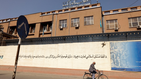 Un hombre en bicicleta pasa por delante del edificio del Banco de Afganistán, en Kabul. REUTERS/Jorge Silva