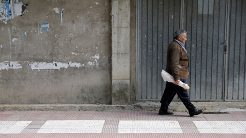 Un pensionistas camina por una calle del pueblo burgalés de  Briviesca. AFP / César Manso