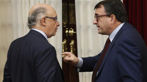 El ministro de Hacienda, Cristóbal Montoro, y el portavoz parlamentario del PNV, Aitor Esteban, dirimen diferencias durante la última sesión de control al Ejecutivo. /EFE