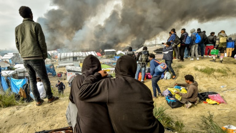 Imagen de octubre de 2016. Varios inmigrantes que vivían en la Jungla de Calais observan el desmantelamiento del campamento. - AFP