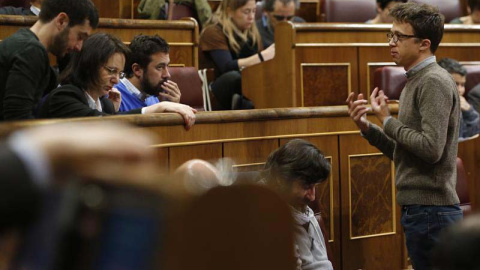 Íñigo Errejón (derecha) conversa con varios compañeros de partido durante la sesión de control al Gobierno celebrada en el Congreso el pasado 11 de abril de 2018. | (JAVIER LIZÓN | EFE)