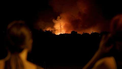 Varias personas observan el avance del incendio en la localidad de Ravelo, en Tenerife. REUTERS/Vini Soares