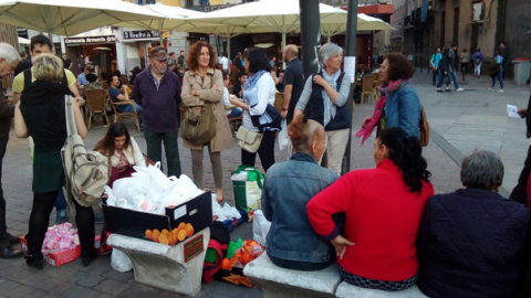 Voluntarios de Casa Solidaria reparten cenas en la plaza de Tirso de Molina de Madrid. / RAÚL GIGLIO