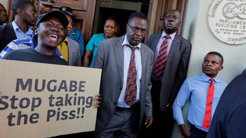 Manifestantes protestan mientras los diputados asisten a la sesión parlamentaria en Harare. | KIM LUDBROOK (EFE)