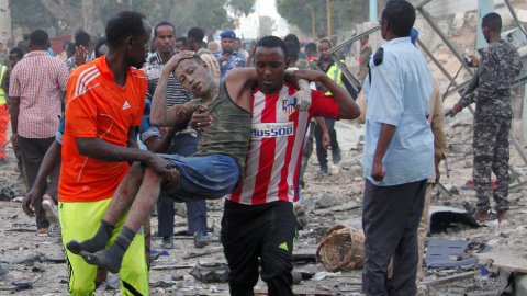 Ciudadanos asisten a un hombre, herido tras la explosión de un coche bomba en Somalia. REUTERS/Feisal Omar