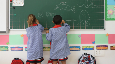 Dos niños pintan en una pizarra el día de inicio del curso en el colegio de la Alameda de Osuna, a 5 de septiembre de 2022, en Madrid (España).