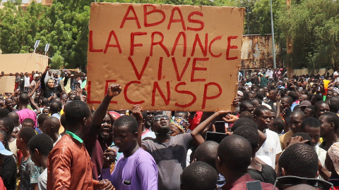 Varios manifestantes sostienen un cartel que dice "Abajo Francia, larga vida al CNSP" durante una marcha en apoyo de los golpistas en Niamey, a 30/07/2023.