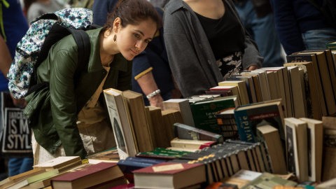 Una joven busca un libro en una de las paradas de las Ramblas de Barcelona.- EFE