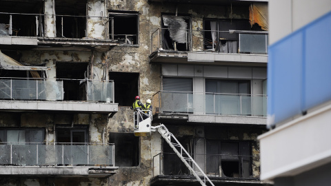 Bomberos trabajan en la limpieza del edificio incendiado, en el barrio de Campanar, a 27 de febrero de 2024, en València, País Valencià.