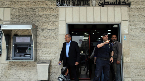 Un policía de Hamás gesticula ante la entrada de un banco en la ciudad de Gaza. | (REUTERS/Ibraheem Abu Mustafa)