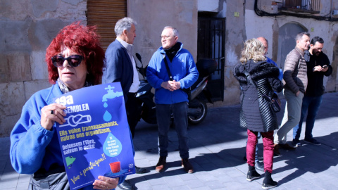 Una activista de la PDE morta un cartell de la 19a assemblea de l'entitat, amb representants del movimebnt social, econòmics i polítics parlant davant la delegació de la Generalitat, a Tortosa