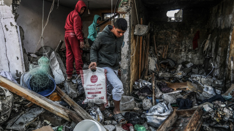 13/03/2024 Un niño palestino saca una bolsa de harina de una casa destruida tras un ataque aéreo israelí.