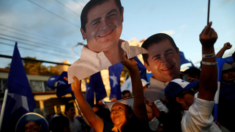 Los partidarios de Hernández sostienen figuras del candidato a la reelección mientras esperan los resultados oficiales de las elecciones presidenciales en Tegucigalpa. / Reuters