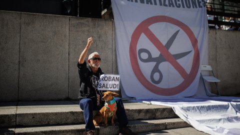 Un manifestante sostiene un cartel que dice 'Roban salud' en la 98ª Marea Blanca por la Sanidad Pública, en la plaza de Juan Goytisolo, a 19 de marzo de 2023, en Madrid, (España).