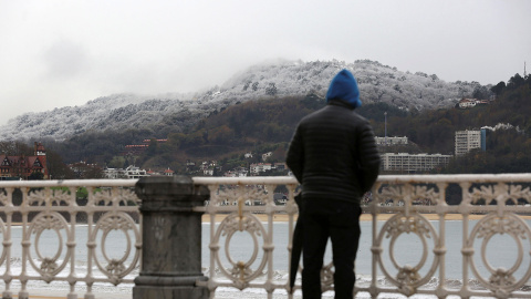 Un hombre observa la nieve caída en San Sebastián. EFE/ Gorka Estrada