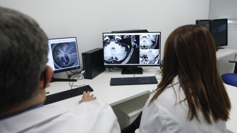 Foto de archivo de unos sanitarios observando la radiografía de un cerebro.