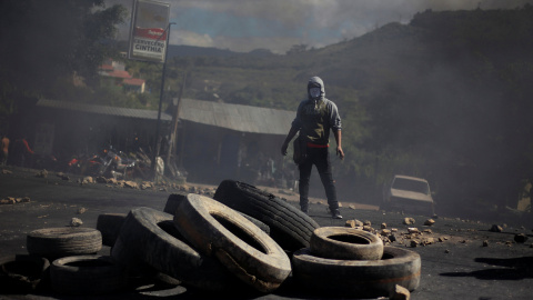 Uno de los manifestantes contra el presunto fraude electoral en Honduras tras una barricada en las calles de Tegucigalpa.REUTERS/Jorge Cabrera