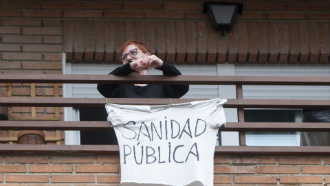 Una vecina coloca una pancarta que reza 'Sanidad Pública' para apoyar una manifestación por la sanidad pública en Villa de Vallecas, a 5 de marzo de 2023, en Madrid (España).