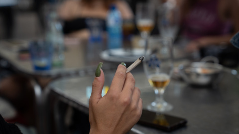 Una mujer fuma sentada en la mesa de una terraza de Barcelona, a 23 de septiembre de 2022.