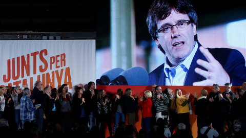 El president destituido Carles Puigdemont aparece en una pantalla durante el mitin de comienzo de la campaña electoral para el 21-D de Junts per Catalunya, en Barcelona. REUTERS/Javier Barbancho