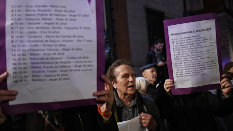 Un grupo de personas que se ha concentrado para protestar por el repunte de asesinatos machistas este mes, muestran carteles con los nombres de las fallecidas, frente al Ministerio de Justicia, a 29 de diciembre de 2022, en Madrid