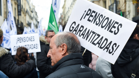 Un hombre con una pancarta que reza '¡Pensiones garantizadas!' en una marcha por el blindaje de las pensiones en Madrid. E.P./Gustavo Valiente