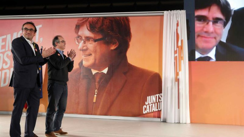 Los exconsellers y candidatos de JxSí Jordi Turull y Josep Rull (i) hablan por videoconferencia con el expresidente Puigdemont durante la rueda de prensa que han ofrecido después de salir de prisión. EFE/Toni Albir