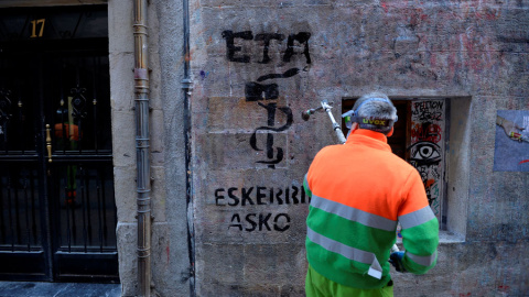 Un emlpeado municipal limpia en Bilbao una pintada que dice, en vasco, 'ETA gracias', dos días después del anuncio de disolución de la organización terrorista. REUTERS/Vincent West