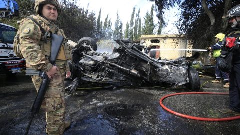 Un bombero apaga un automóvil en llamas atacado por un dron israelí en Al Hoash Road, en el sur del Líbano, el 13 de marzo de 2024.