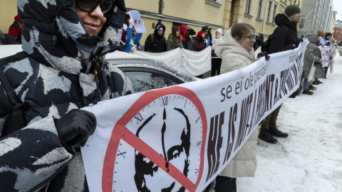 Manifestantes sostienen una pancarta con una imagen tachada de Vladimir Putin en Helsinki, Finlandia, el 17 de marzo de 2024.