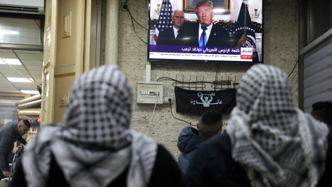 Palestinos escuchan el discurso de Trump en el que reconoce oficialmente a Jerusalén como capital de Israel. REUTERS/Ammar Awad