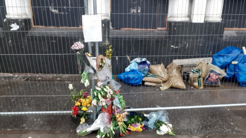 Flores depositadas en memoria de Lidia Venegas en la acera en la que vivió los ultimo seis meses de su vida.