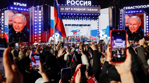 Unas pantallas gigantes muestran el rostro del presidente de Rusia, Vladimir Putin, en un acto en la Plaza Roja de Moscú, para conmemorar el décimo aniversario de la anexión rusa de Crimea de Ucrania, un día después de ser declarado de las recientes 