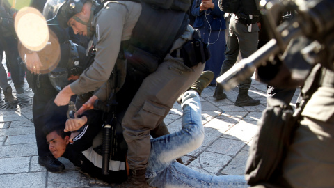 Un policía israelí detiene a un joven palestino cerca de la Puerta de Damasco, en Jerusalén, tras la oración del viernes. REUTERS/Ronen Zvulun