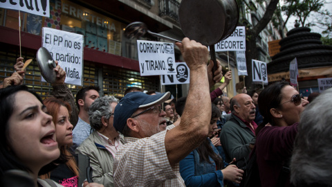 Un manifestante protesta frente a la sede del PP.- JAIRO VARGAS