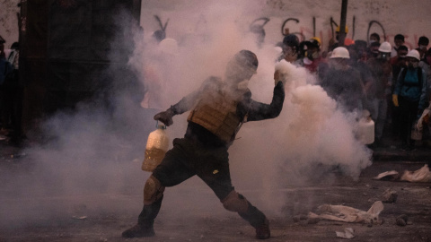 Un manifestante choca con la policía antidisturbios durante una protesta contra el gobierno de la presidenta peruana Dina Boluarte