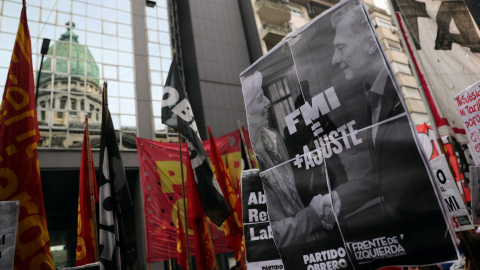 Un manifestante sostiene una pancarta con la imagen del la directora gerente del FMI, Christine Lagarde, y del presidente argentino, Mauricio Macri, en una protesta frente al Congreso, en Buenos Aires. REUTERS/Marcos Brindicci