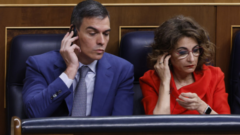 El presidente del Gobierno, Pedro Sánchez, y la vicepresidenta primera y ministra de Hacienda, María Jesús Montero, hacen uso de sistema de traducción durante la sesión de control al Gobierno celebrada, en el Congreso de los Diputados. EFE/Javier Liz