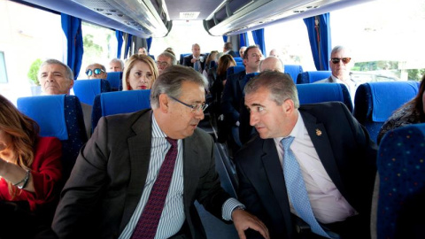 Fotografía facilitada por el Ministerio del Interior del titular del Departamento, Juan Ignacio Zoido (i), conversando con Miguel Folguera, de la asociación Plataforma de apoyo a las víctimas, en el autocar que traslada a los representantes de asociaci