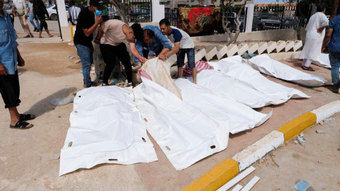 Varias personas buscan entre los cadáveres a familiares y conocidos tras el paso devastador del ciclón Daniel por la ciudad de Derna, en Libia.