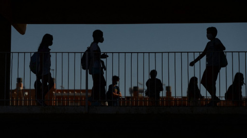 Varios alumnos en el patio de un colegio.