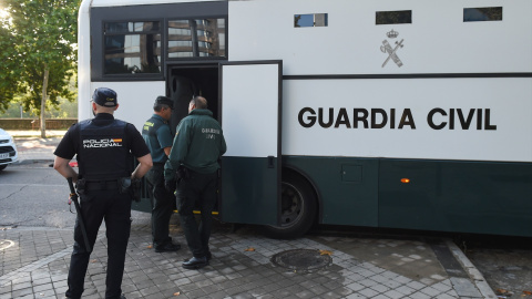 Varios agentes de la Guardia Civil y de Policía Nacional junto a un autobús de la Guardia Civil.