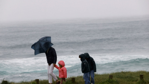 Una familia pasea por la costa de Ferrol con el temporal Nelson. 27/03/2024