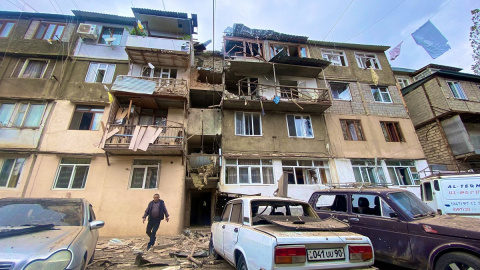 Una vista muestra un edificio residencial y automóviles dañados tras el lanzamiento de una operación militar por parte de las fuerzas armadas de Azerbaiyán en la ciudad de Stepanakert en Nagorno-Karabaj, una región habitada por personas de etnia arme