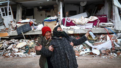 Dos mujeres se lamentan junto a un edificio derrumbado tras el gran terremoto en el distrito de Elbistan de Kahramanmaras, en Turquía.