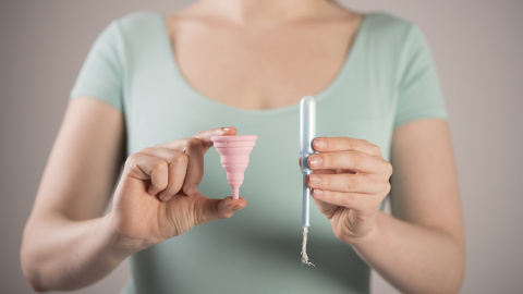 Imagen de una copa menstrual y un tampón.